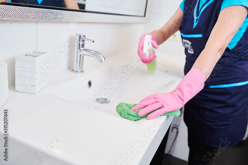 Fototapeta Naklejka Na Ścianę i Meble -  cleaning service. wiping bathroom wash basin