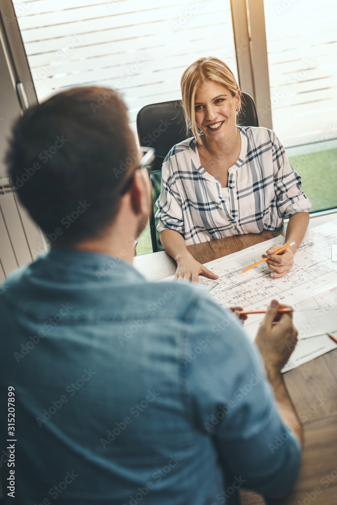 Obraz premium Young Architects Analyzing Blueprints