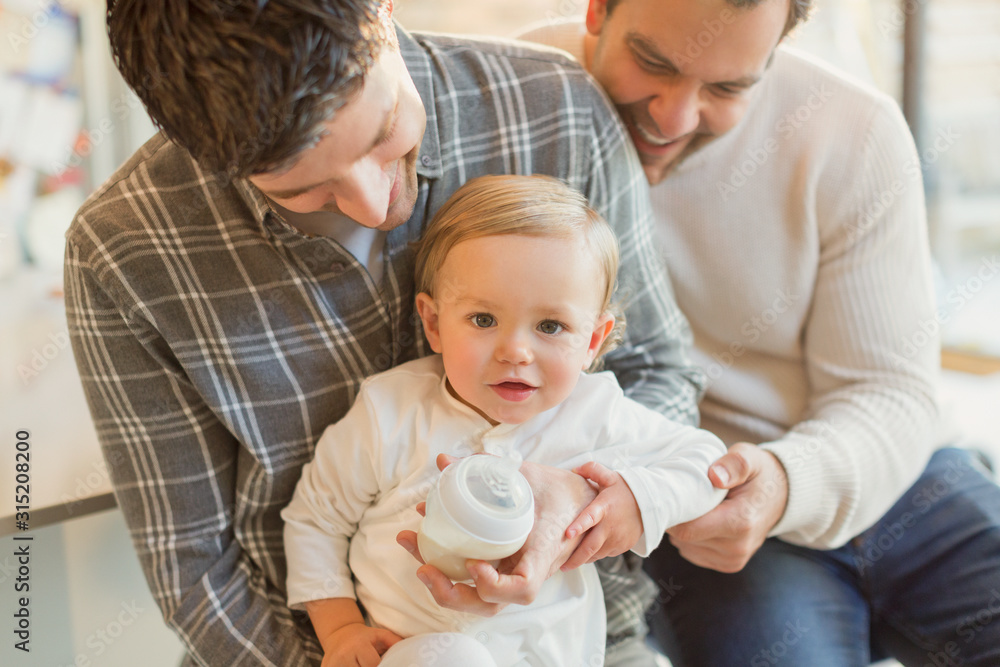 Portrait cute baby son with male gay parents Portrait cute baby son with male gay parents