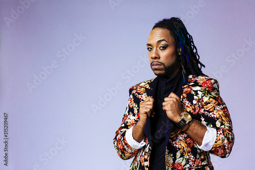 Studio portrait of a man wearing a flower patterned suit and dreadlocks photo