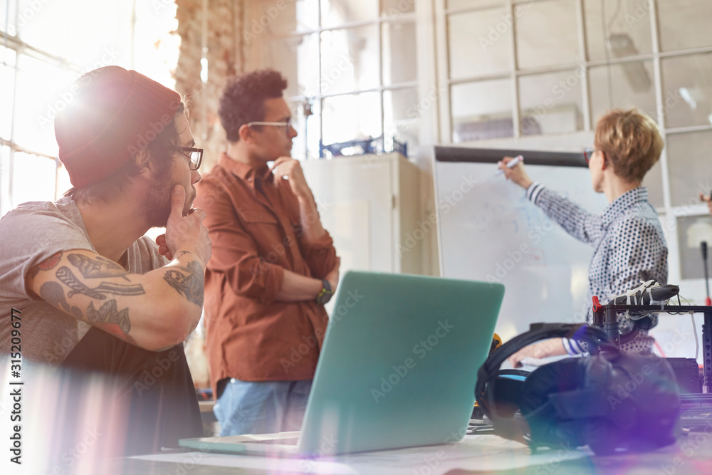 © Rafal Rodzoch/Caia Image - Designers meeting, brainstorming at whiteboard in office