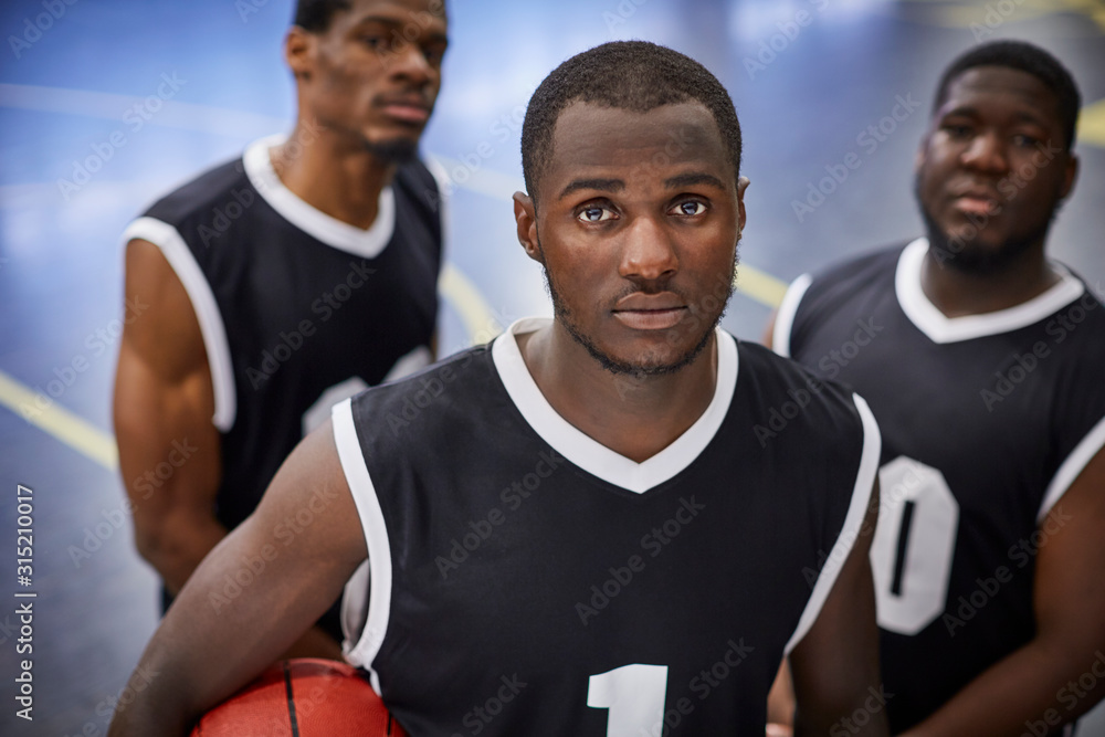Portrait serious, focused young male basketball player team wearing black jerseys Portrait serious, focused young male basketball player team wearing black jerseys