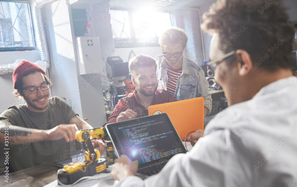 © Agnieszka Olek/Caia Image - Computer programmers programming robotics in workshop