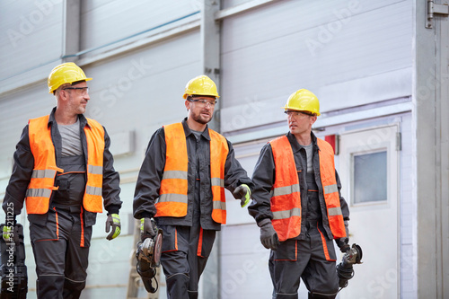 Male workers in protective clothing walking photo