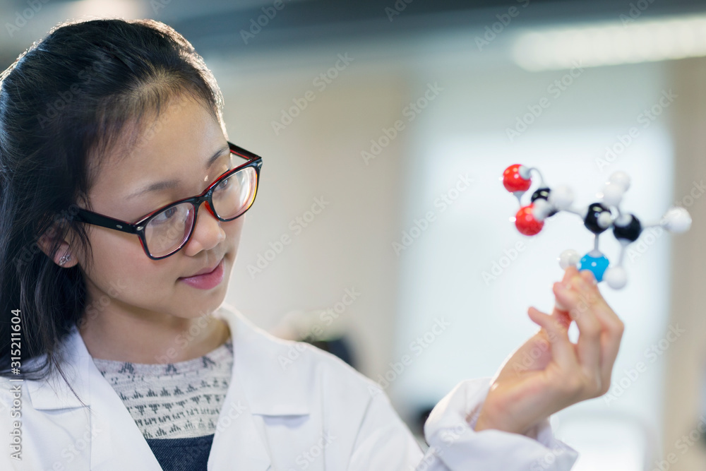 Curious girl student examining molecular structure in classroom Curious girl student examining molecular structure in classroom
