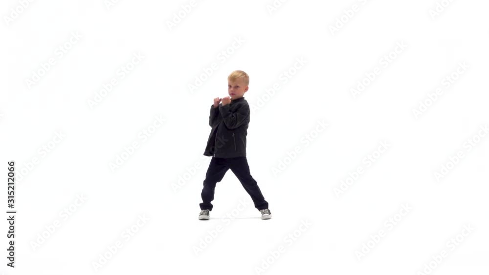 Little boy is dancing a modern dance on the white background in black leather jackets and jeans. Slow motion. Little boy is dancing a modern dance on the white background in black leather jackets and jeans. Slow motion.