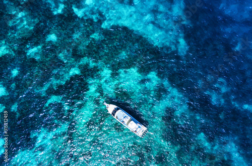 Aerial view of luxury floating cruise ship on transparent turquoise water at sunny day. Top view from drone. Seascape with cruise ship. Travel - image © biletskiyevgeniy.com
