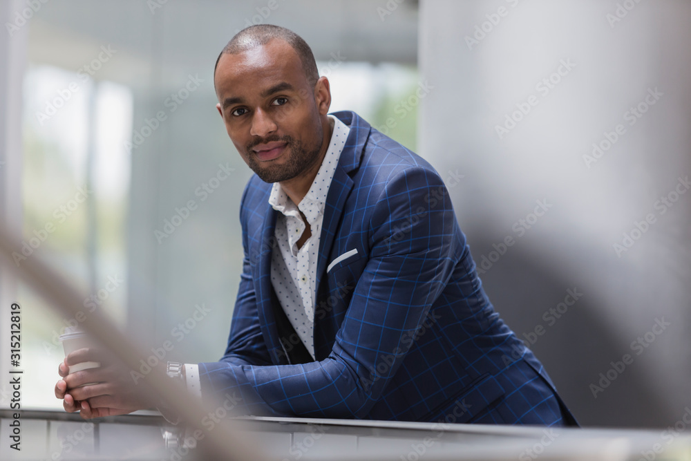 Portrait confident businessman leaning on railing Portrait confident businessman leaning on railing