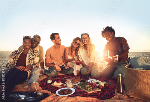 Portrait young friends hanging out, enjoying picnic on sunny summer beach photo