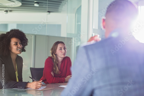 Attentive businesswomen listening in conference room meeting