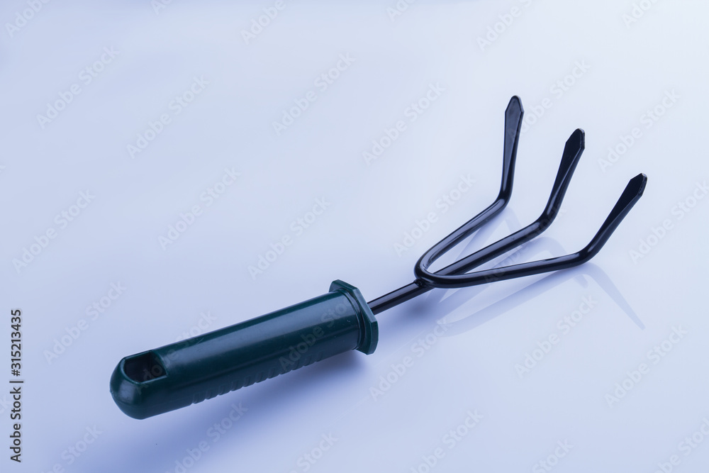 Short three jaw rake. White isolated background. Short three jaw rake. White isolated background.