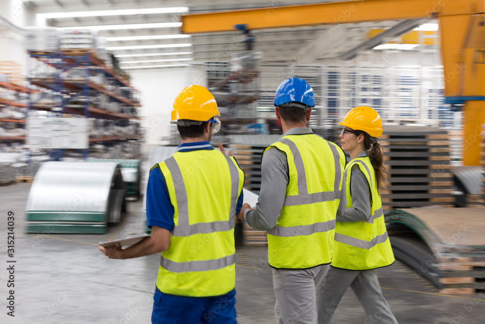Workers walking and talking in factory Workers walking and talking in factory