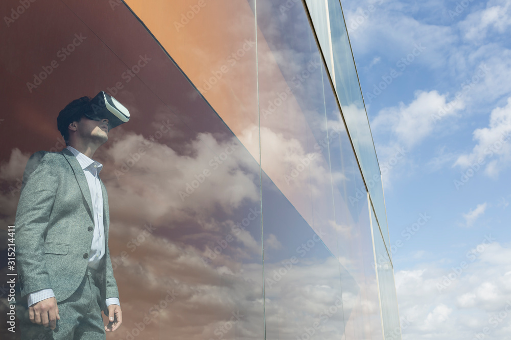 © Caiaimage/Martin Barraud/Caia Image - Businessman using virtual reality simulator glasses at modern window cloud reflection © Caiaimage/Martin Barraud/Caia Image - Businessman using virtual reality simulator glasses at modern window cloud reflection
