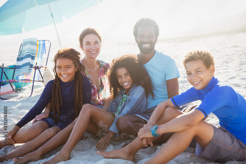 Portrait smiling multi-ethnic family on sunny summer beach
