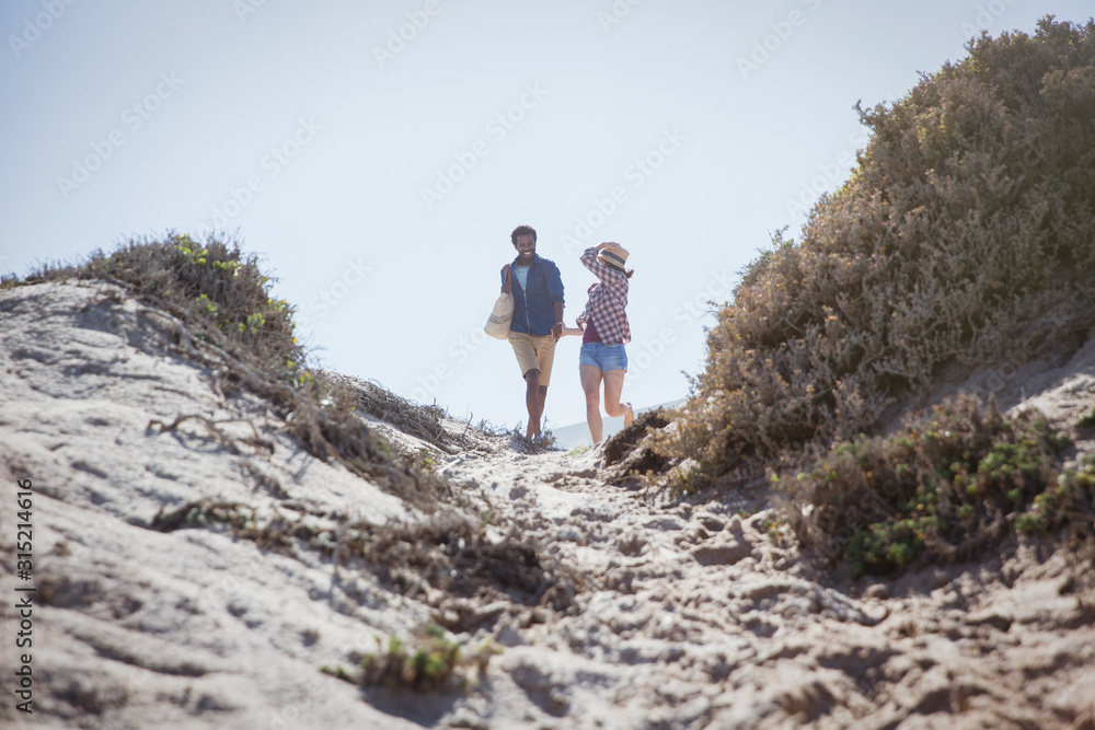Couple walking on sunny summer beach path Couple walking on sunny summer beach path