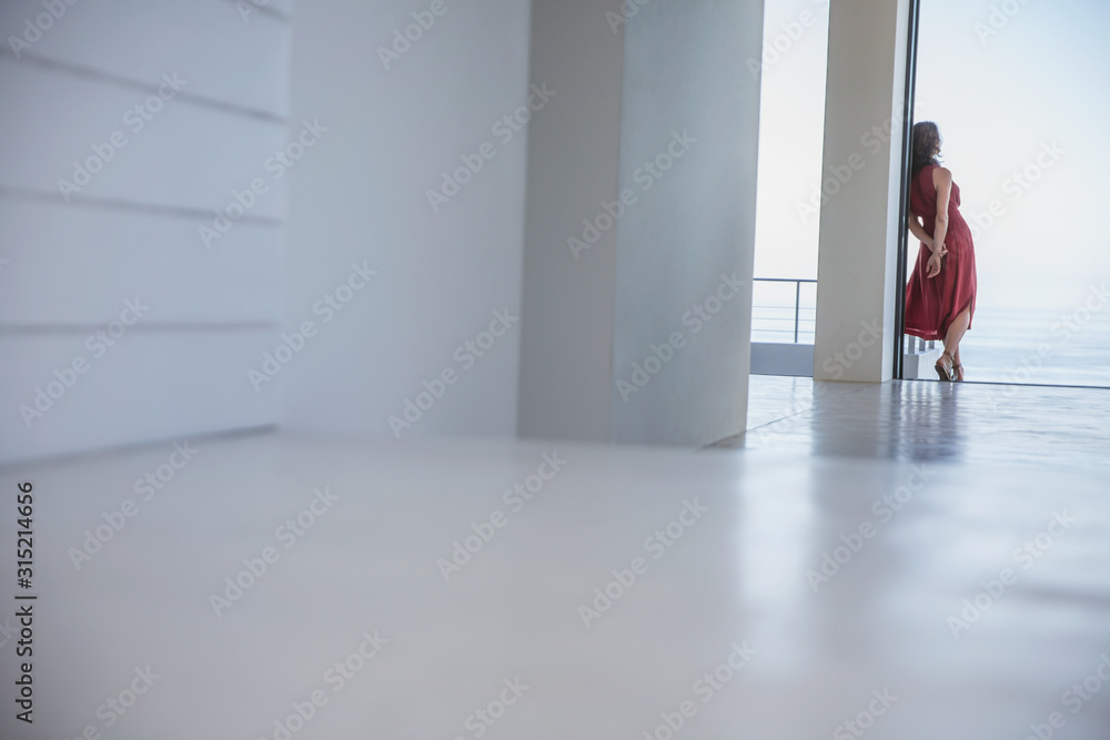 Woman in blue dress standing in patio doorway Woman in blue dress standing in patio doorway