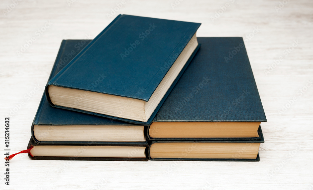 stack of blue books on wooden bookshelf stack of blue books on wooden bookshelf