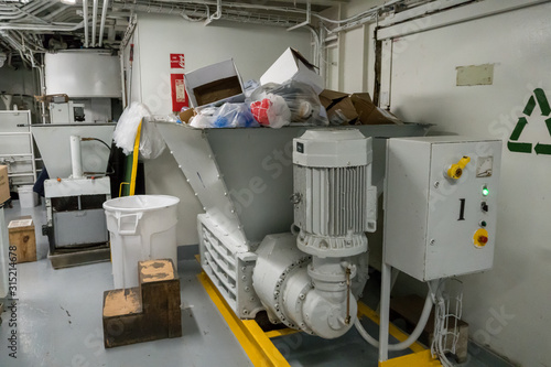 Incinerator room on board a cruise ship. Recycling center with garbage. Metal machines are very important for the life at sea. Pollution of the environment is not gonna happen with segregation.