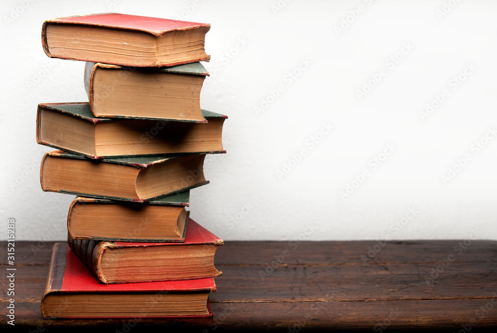 stack of old books on wooden table stack of old books on wooden table