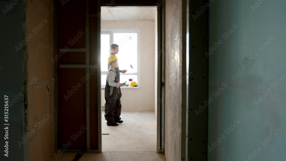 Family repair draft apartment - little boy and his father painting wall Family repair draft apartment - little boy and his father painting wall