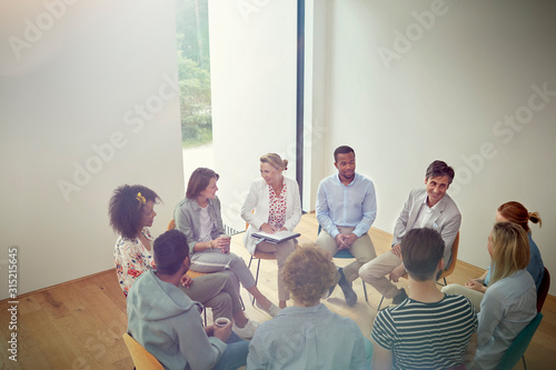 People talking in a circle in group therapy session photo