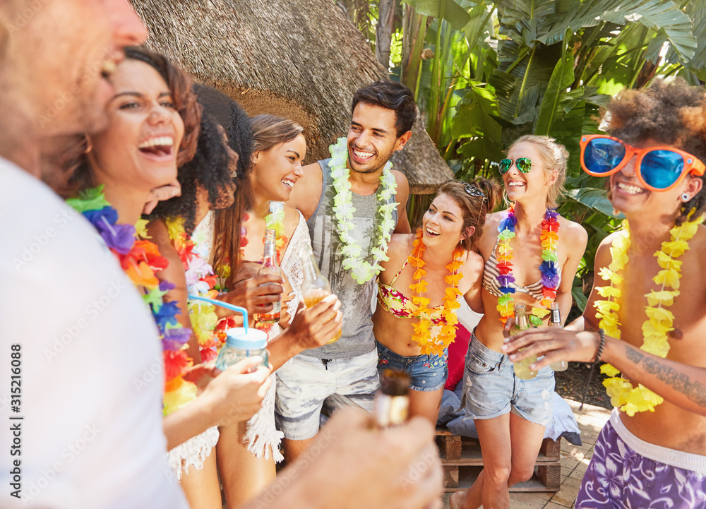 Young friends wearing leis, hanging out at summer poolside Young friends wearing leis, hanging out at summer poolside