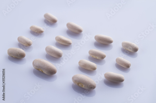 Disposed rows of white beans. Bright isolated background.