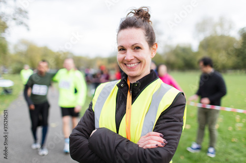 Portrait smiling female volunteer at charity run in park photo