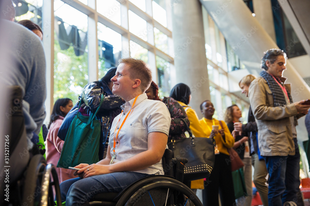 Smiling woman in wheelchair at conference Smiling woman in wheelchair at conference