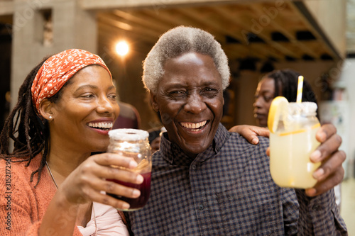 Happy senior father and daughter drinking lemonade and sangria