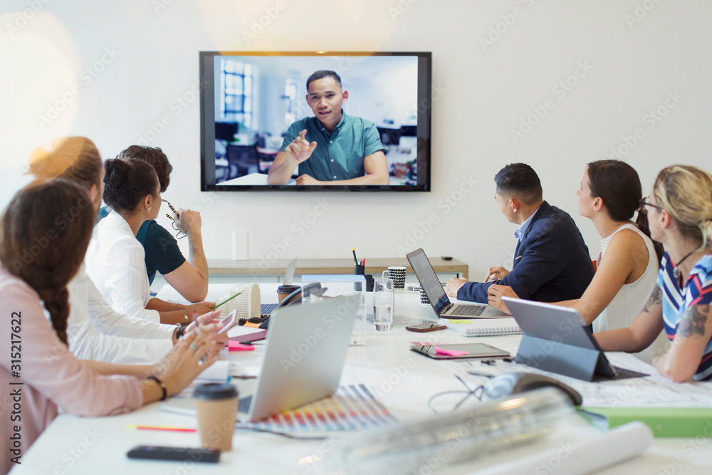 Designers video conferencing with colleague in conference room meeting Designers video conferencing with colleague in conference room meeting