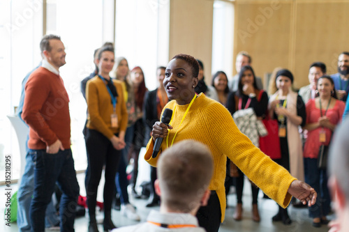 Audience listening to female speaker with microphone