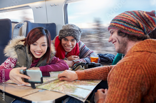 Wallpaper Mural Young friends map taking selfie selfie stick on passenger train Torontodigital.ca