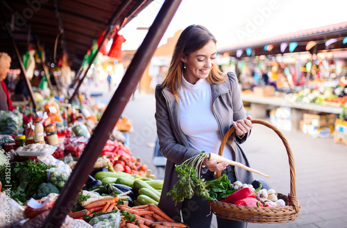 A woman shopping for vegetables at the farmer's market.