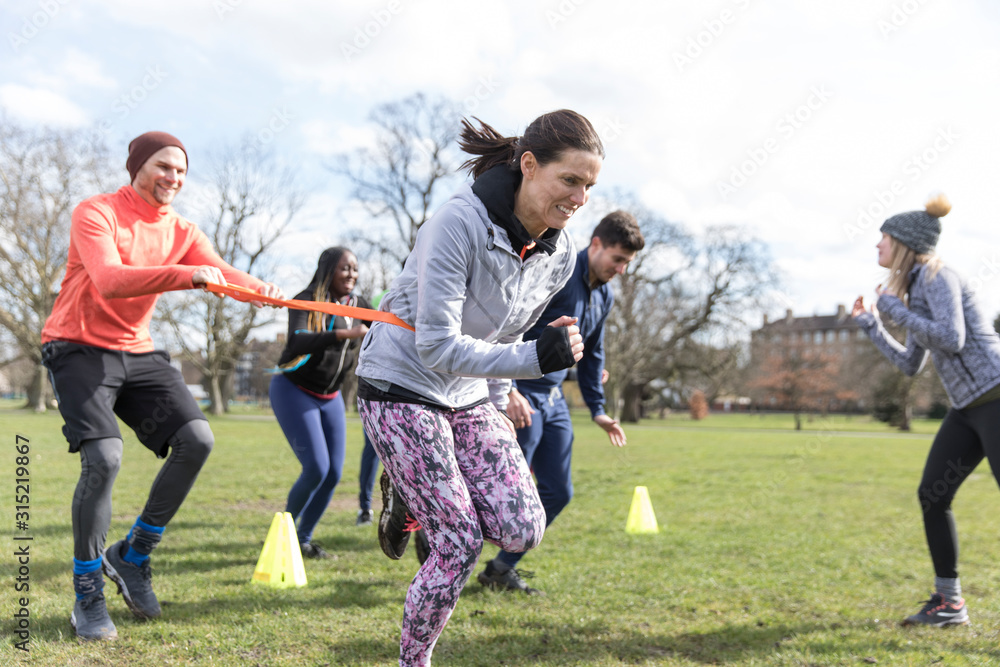 People racing, doing team building exercise in sunny park People racing, doing team building exercise in sunny park