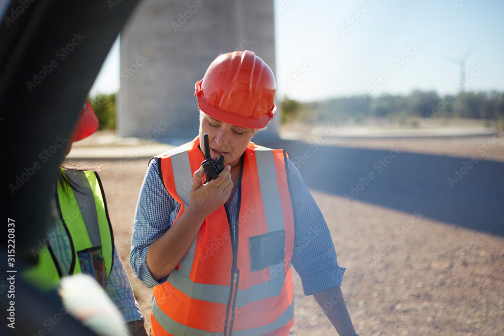 © Trevor Adeline/Caia Image - Female worker using walkie-talkie at power plant © Trevor Adeline/Caia Image - Female worker using walkie-talkie at power plant