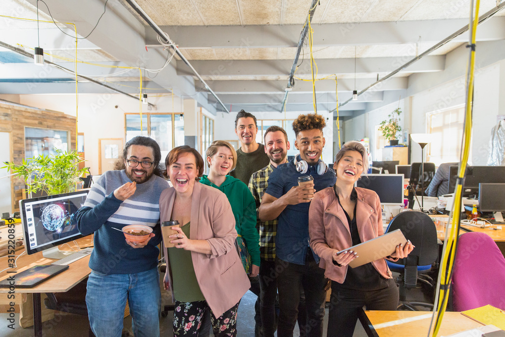 Portrait happy, playful creative business team in open plan office Portrait happy, playful creative business team in open plan office