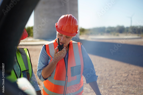 Female worker using walkie-talkie at power plant photo