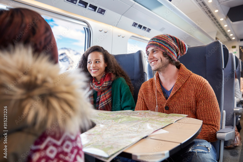 © Agnieszka Olek/Caia Image - Smiling young friends planning with map on passenger train © Agnieszka Olek/Caia Image - Smiling young friends planning with map on passenger train