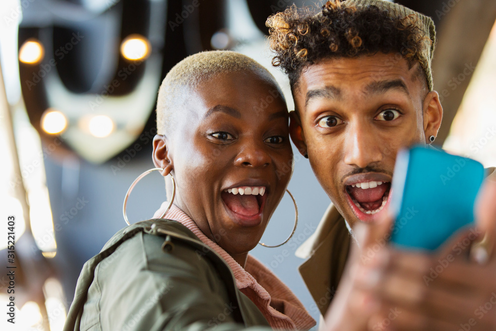 © Chris Ryan/Caia Image - Playful young couple taking selfie with camera phone © Chris Ryan/Caia Image - Playful young couple taking selfie with camera phone