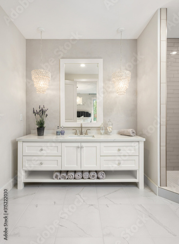 Bathroom in luxury home with vanity  mirror  sink  and tile floor