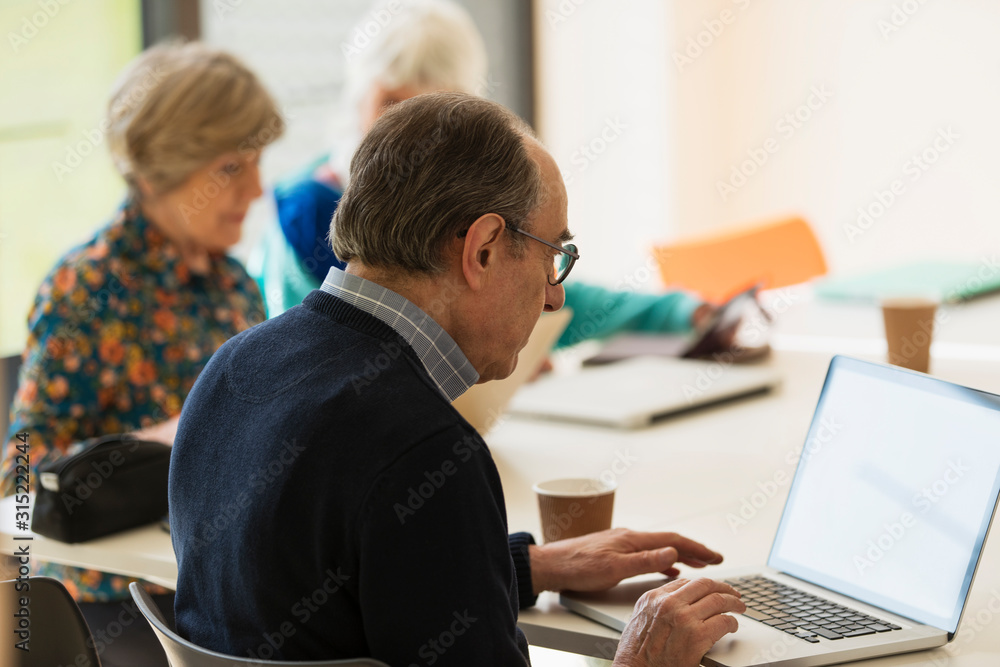 Senior businessman using laptop in meeting Senior businessman using laptop in meeting