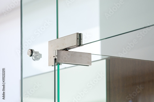 Canvas Print glass door with iron hinges, close up of fastenings for a transparent door