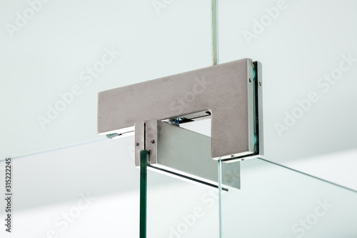 glass door hinges metal fittings with door locking mechanism, close up.