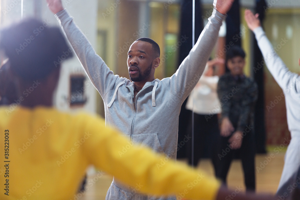 © Sam Edwards/Caia Image - Male instructor leading dance class in studio