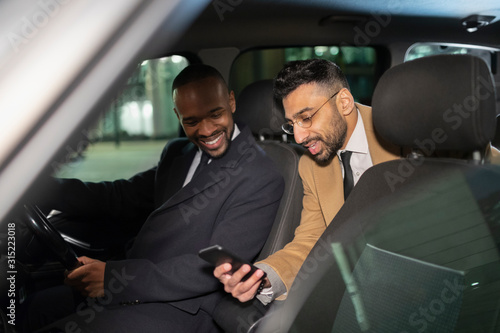 Businessman with smart phone using crowdsourced taxi photo