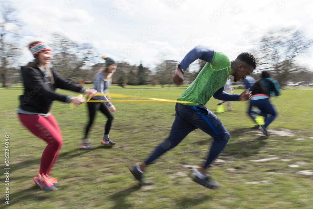 People racing, doing team building exercise in sunny park People racing, doing team building exercise in sunny park
