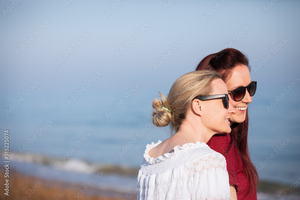 Affectionate lesbian couple on sunny beach Affectionate lesbian couple on sunny beach