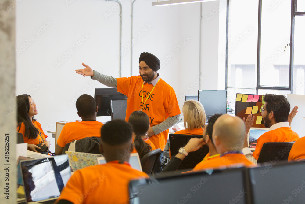 © Martin Barraud/Caia Image - Hacker in turban leading meeting, coding for charity at hackathon