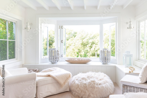 White home showcase sitting area with windows open to garden
